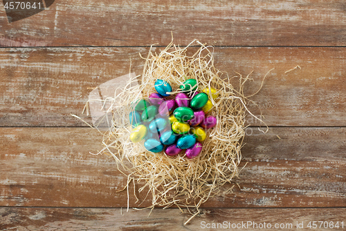 Image of chocolate eggs in foil wrappers in straw nest