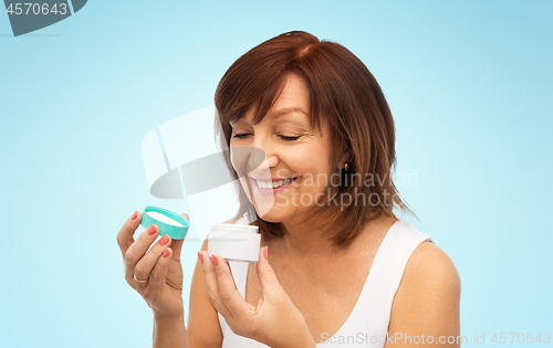 Image of smiling senior woman with cream jar