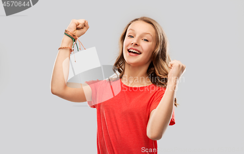 Image of happy teenage girl in red celebrating triumph