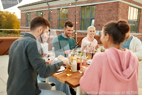 Image of friends having dinner or rooftop party in summer