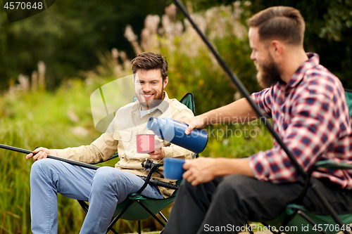 Image of friends fishing and drinking tea from thermos