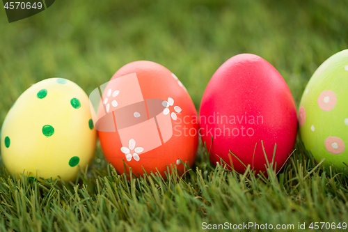 Image of row of colored easter eggs on artificial grass