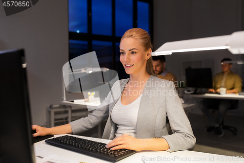 Image of businesswoman working on computer at night office