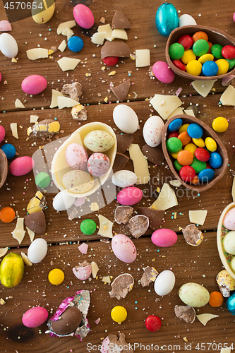 Image of chocolate eggs and candy drops on wooden table