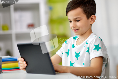 Image of student boy with tablet pc and notebook at home