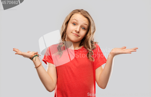 Image of wondering teenage girl in red t-shirt shrugging