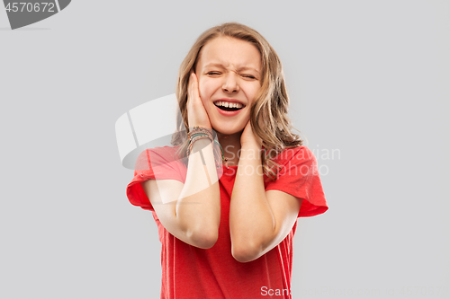 Image of annoyed teenage girl covering her ears with hands