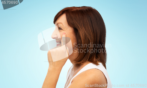 Image of profile of senior woman pointing to eye wrinkles