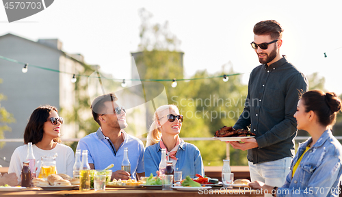 Image of friends at bbq party on rooftop in summer