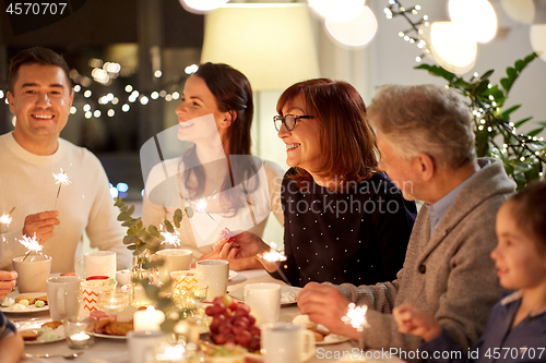 Image of family with sparklers having tea party at home