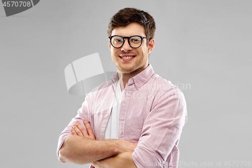 Image of smiling young man in glasses over grey background