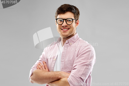 Image of smiling young man in glasses over grey background
