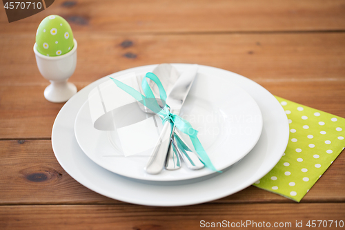 Image of easter egg in cup holder, plates and cutlery