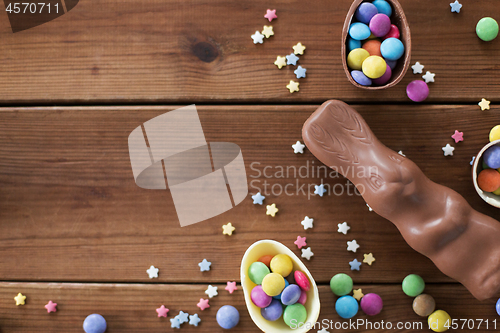 Image of chocolate eggs, easter bunny and candies on wood