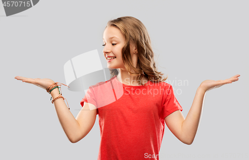 Image of smiling teenage girl holding empty hand