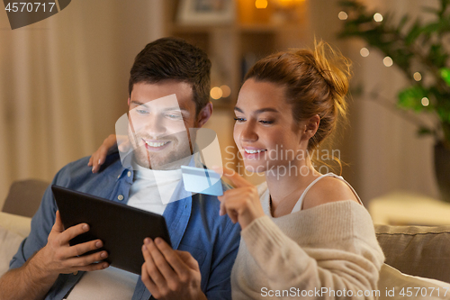 Image of couple with tablet pc and credit card at home