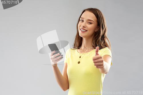 Image of teenage girl with smartphone showing thumbs up