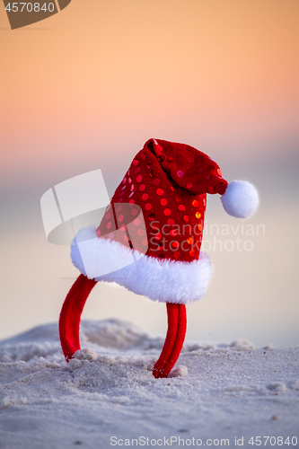 Image of Sparkly red santa hat in the beach sand in Australia. Christmas