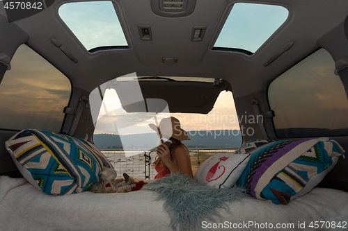 Image of Woman on road trip with her van has a rest break