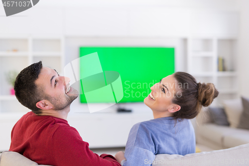 Image of Young couple on the sofa watching television