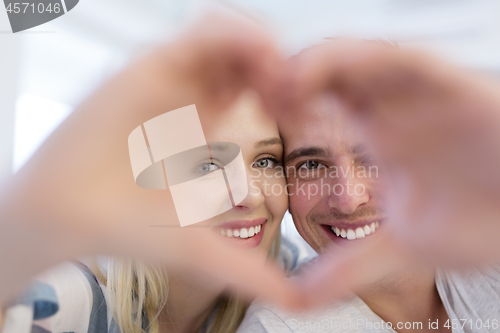 Image of couple making heart with hands