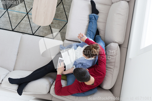 Image of couple relaxing at  home with tablet computers