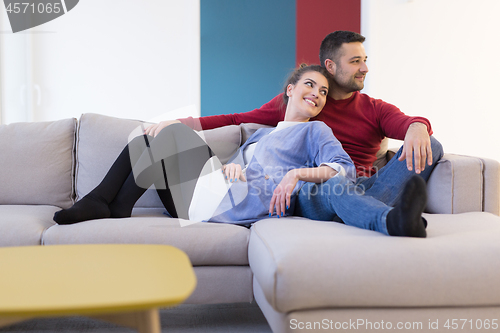 Image of couple hugging and relaxing on sofa