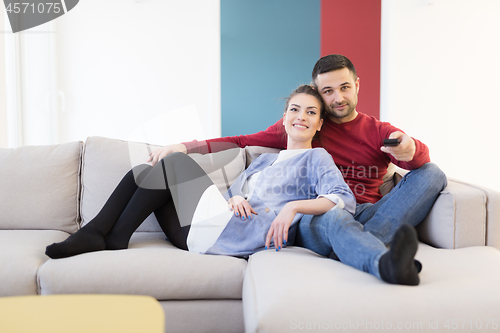 Image of Young couple on the sofa watching television