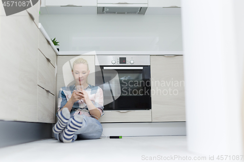 Image of young women using mobile phone at home