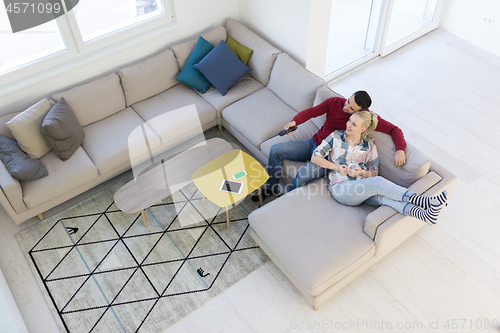 Image of Young couple on the sofa watching television