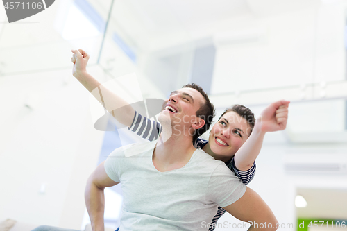 Image of handsome man piggybacking his girlfriend