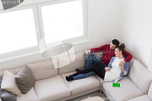 Image of Young couple on the sofa watching television