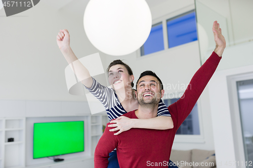 Image of handsome man piggybacking his girlfriend