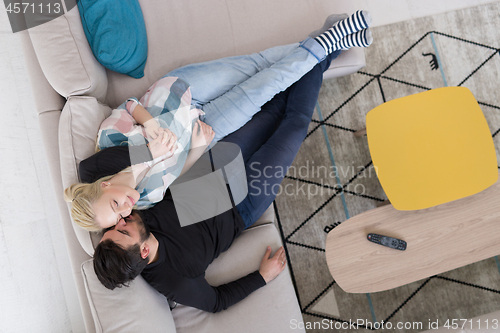 Image of Young couple on the sofa watching television top view