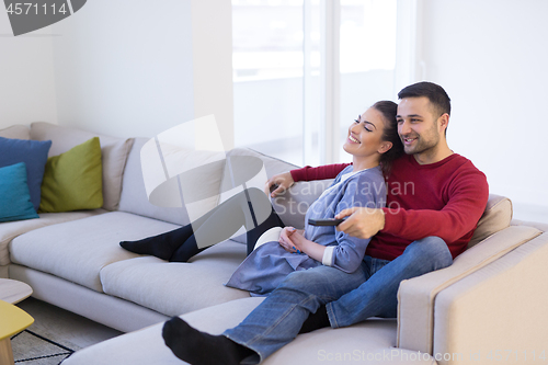 Image of Young couple on the sofa watching television