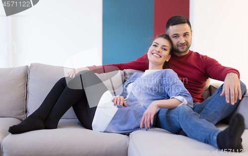 Image of couple hugging and relaxing on sofa