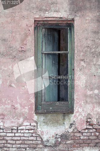 Image of Old window on exposed brick wall.