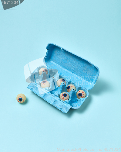Image of Paper tray with eyeballs on a pastel blue background.
