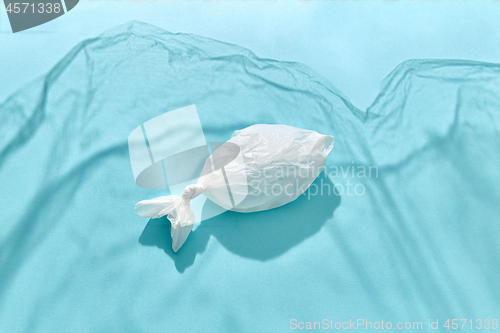 Image of Fish shape of polythene bag on a background fom plastic shadows.