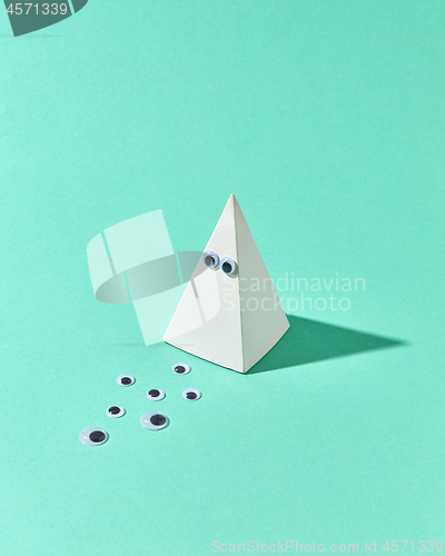 Image of White plastic pyramid with eyes as Halloween simbol.