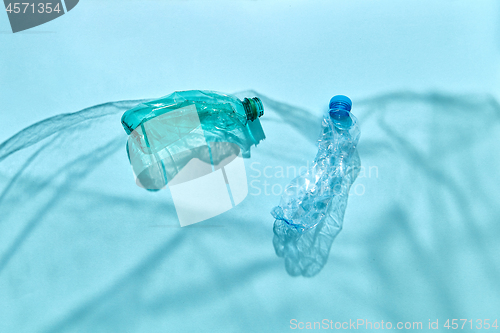 Image of Plastic bottles in the blue ocean waves from plastic foil shadows.