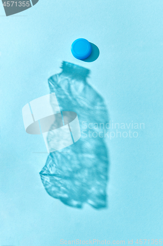 Image of Shadow from crushed plastic bottle with blue top.