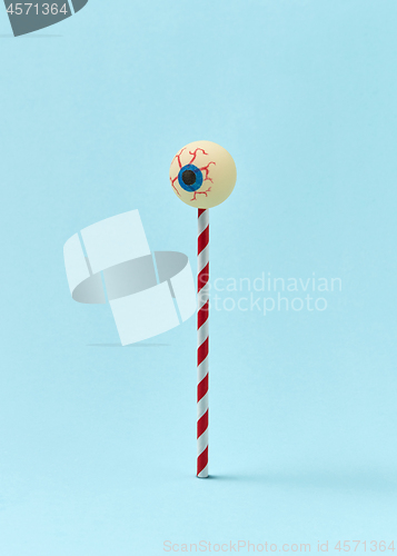 Image of Human eyeball on a plastic straw as a candy.