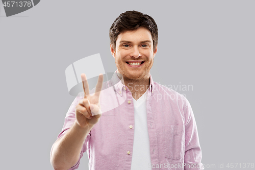 Image of young man showing two fingers or peace hand sign