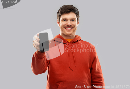 Image of smiling man in red hoodie showing black smartphone