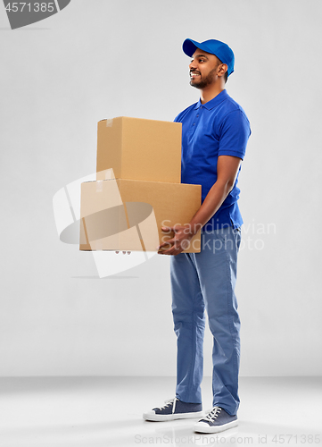 Image of happy indian delivery man with parcel boxes