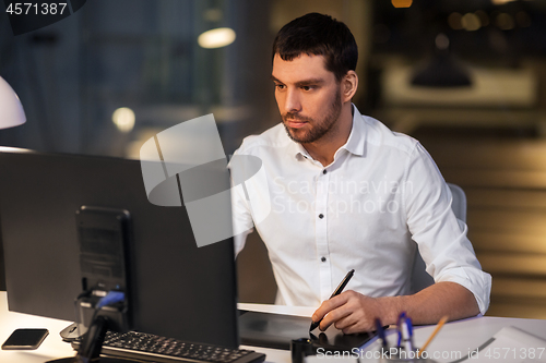 Image of designer with computer and pen tablet at office