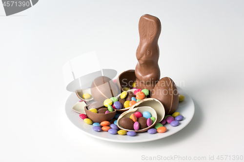 Image of chocolate bunny, eggs and candies on white plate