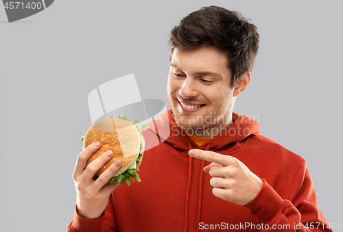 Image of happy young man showing hamburger