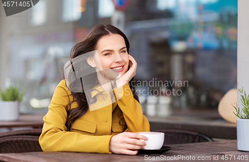 Image of teenage girl drinking hot chocolate at city cafe